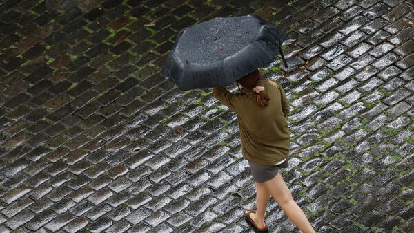 Девушка укрывается от дождя под зонтом - Sputnik Кыргызстан
