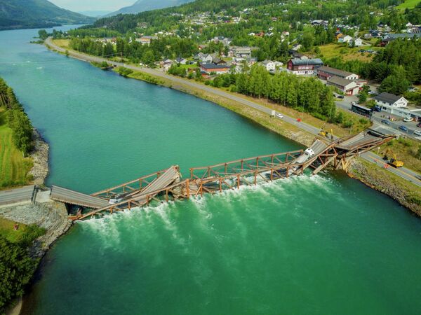 Вид с воздуха на обрушившийся мост Треффен через реку Гудбрандсдальслаген на юге Норвегии. В отчете местной полиции говорится, что легковой автомобиль и грузовик рухнули в реку вместе с мостом. - Sputnik Кыргызстан