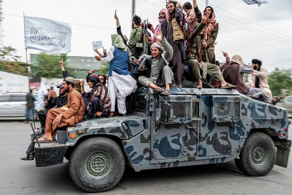 Боевики &quot;Талибана&quot; едут на &quot;Хаммере&quot; возле посольства США в Кабуле, чтобы отпраздновать день победы. Они скандируют победные лозунги в честь первой годовщины победы и их возвращения к власти в Афганистане. - Sputnik Кыргызстан