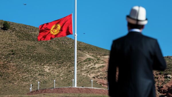 Кыргызстан президенти Садыр Жапаров флагштокту карап жатат. Архив - Sputnik Кыргызстан