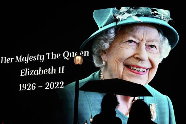 Люди возле огромной фотографии королевы Елизаветы II в центре Лондона. Королева скончалась в возрасте 96 лет. - Sputnik Кыргызстан
