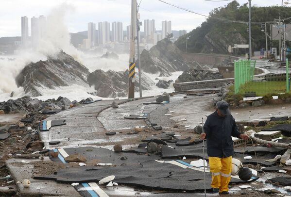 Мужчина идет по набережной в южнокорейском Улсане после тайфуна &quot;Хиннамнор&quot; - Sputnik Кыргызстан