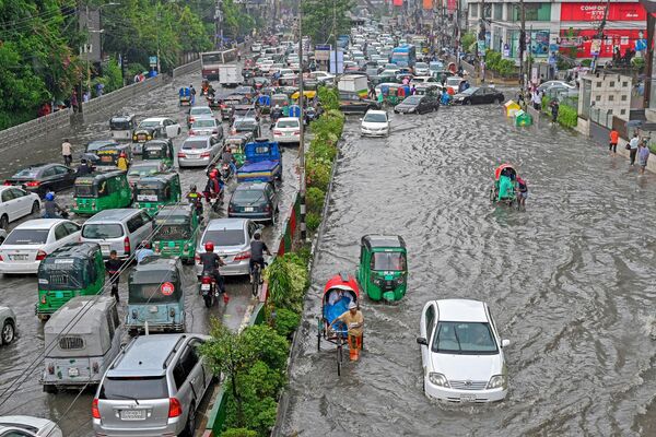 Транспортные средства на улице, затопленной в результате сильных муссонных дождей в Дакке (Бангладеш) - Sputnik Кыргызстан