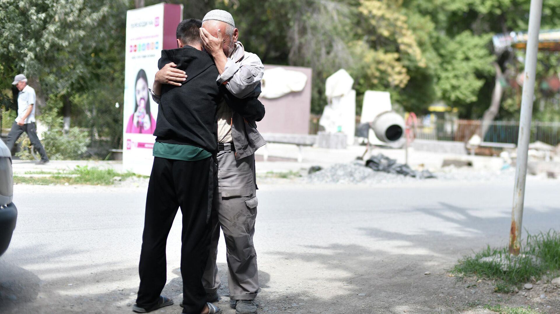 Мужчина обнимает сына в одном из населенных пунктов Баткенской области после обстрела Таджикистаном - Sputnik Кыргызстан, 1920, 18.09.2022