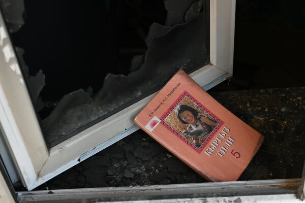 Учебник кыргызского языка возле окна школы в Ак-Сае, обстрелянной таджикскими военными - Sputnik Кыргызстан