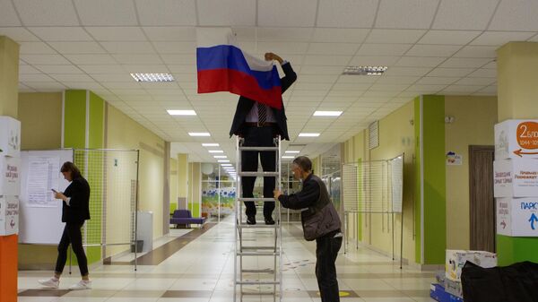 Мужчина вешает флаг РФ. Архивное фото - Sputnik Кыргызстан