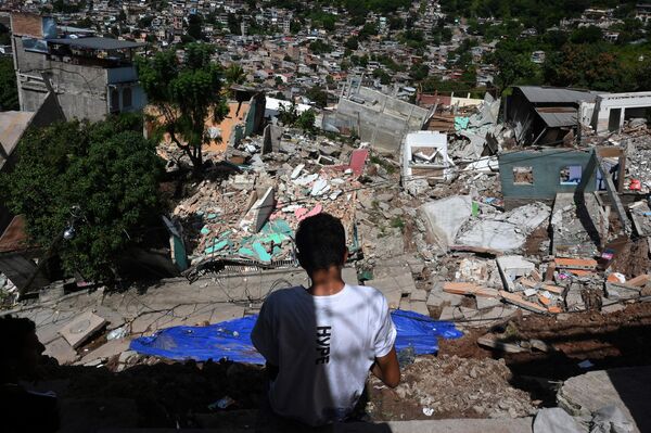 Мужчина смотрит на разрушенные оползнем дома в столице Гондураса - Sputnik Кыргызстан