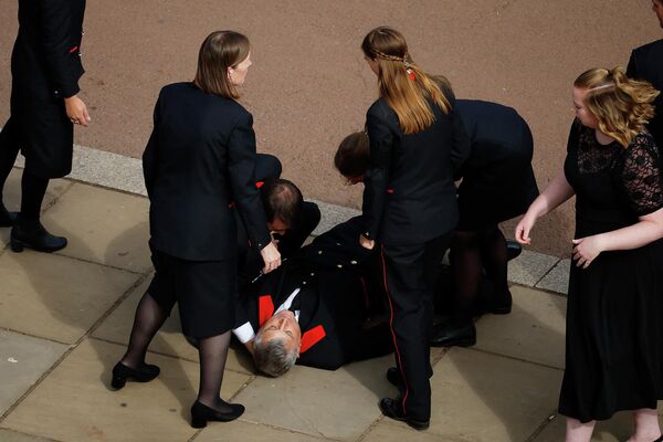 Служащие Букингемского дворца оказывают помощь коллеге, потерявшему сознание во время похорон Елизаветы II - Sputnik Кыргызстан