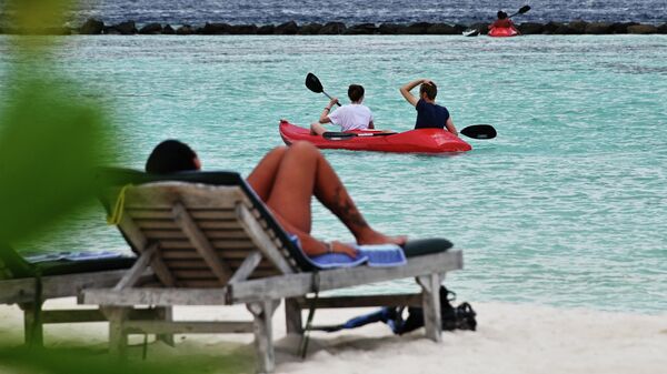Туристы отдыхают на пляже на берегу одного из островов Мальдив. Архивное фото - Sputnik Кыргызстан
