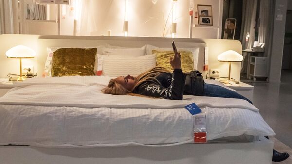 Девушка пользуется телефоном лежа на кровати. Архивное фото - Sputnik Кыргызстан