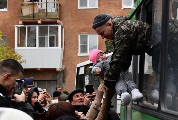 Мужчина, призванный на военную службу в ходе частичной мобилизации, держит на руках ребенка возле Чкаловского районного военкомата в Екатеринбурге - Sputnik Кыргызстан