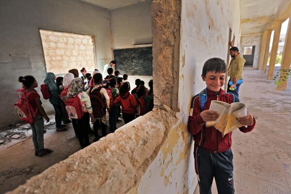 Сирийские дети в классе импровизированной школы на удерживаемой повстанцами стороне разделенного северного города Тадифа, расположенного примерно в 32 километрах к востоку от Алеппо - Sputnik Кыргызстан