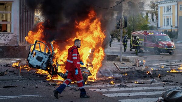 Медицинский работник идет мимо горящей машины после взрыва в Киеве, Украина - Sputnik Кыргызстан