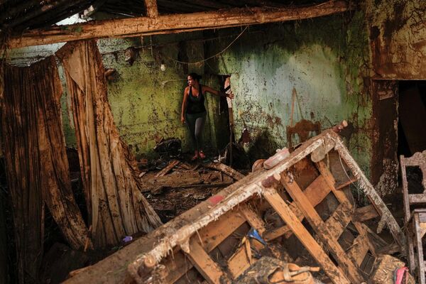 Женщина осматривает свой дом, разрушенный после оползня и наводнения в Венесуэле. Жертвами стихий стали по меньшей мере 43 человека. - Sputnik Кыргызстан