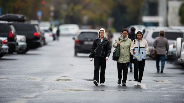 Люди идут по площади Ала-Тоо в Бишкеке после дождя. Архивное фото  - Sputnik Кыргызстан
