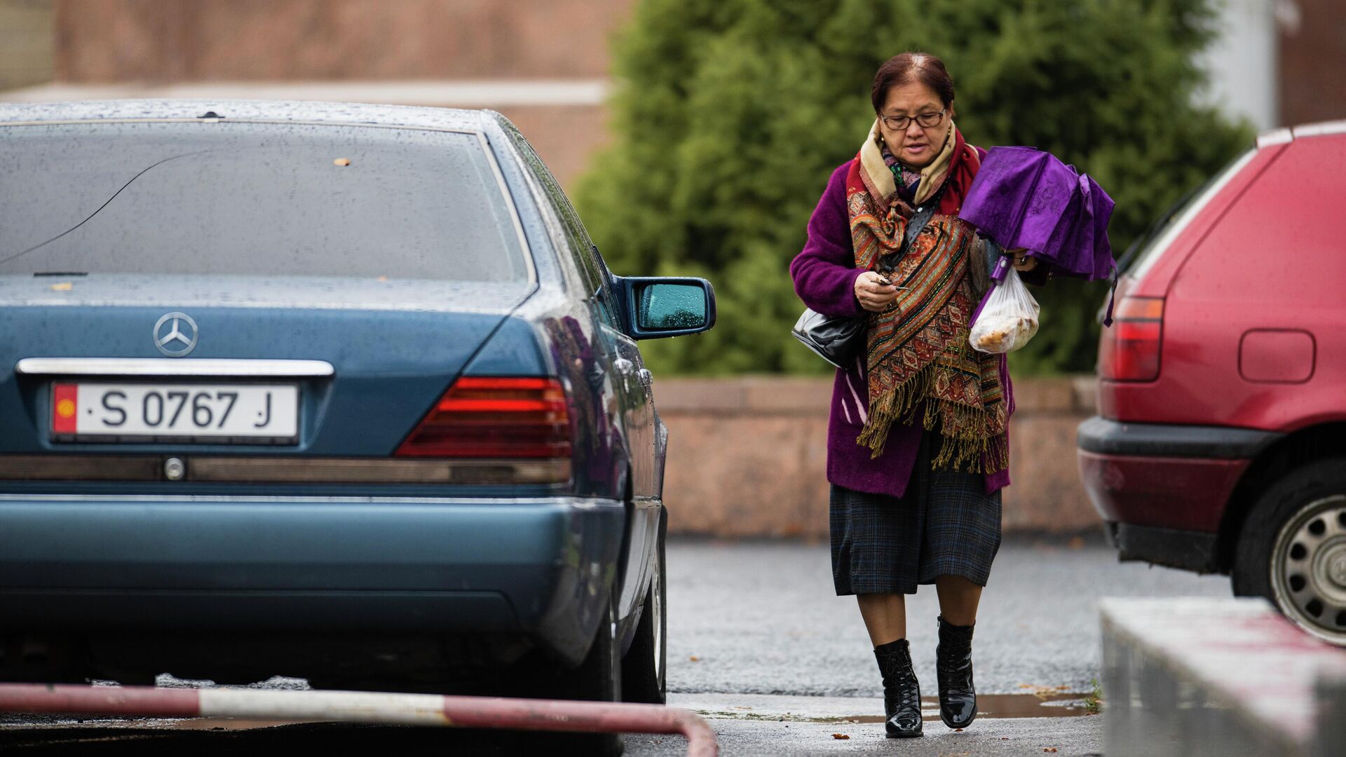 Женщина с зонтом идет по одной из улиц Бишкека в осеннюю погоду - Sputnik Кыргызстан, 1920, 31.10.2022