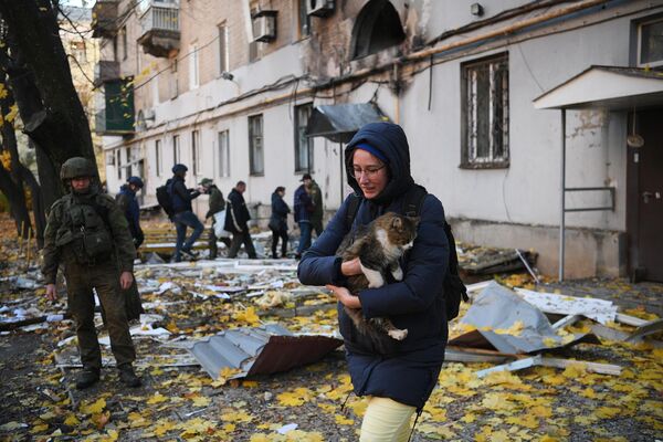 Девушка с кошкой возле жилого дома в Донецке, поврежденного в результате обстрела со стороны ВСУ - Sputnik Кыргызстан