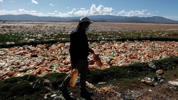 Мужчина с бутылками, которые наполняют реку Тагарет возле Оруро, Боливия. Архивное фото - Sputnik Кыргызстан