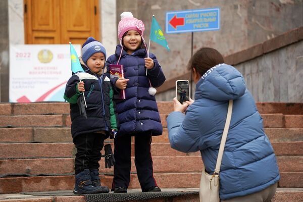 Женщина фотографирует своих детей возле избирательного участка в Алматы. 20 ноября в Казахстане прошли внеочередные выборы президента. Явка составила 69,31%, в течение семи дней ЦИК объявит итоги. - Sputnik Кыргызстан