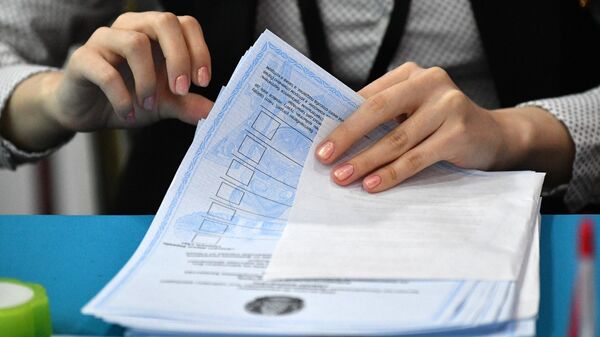 Член избирательной комиссии производит подсчет неиспользованных на внеочередных выборах президента Казахстана бюллетеней на одном из избирательных участков в Астане - Sputnik Кыргызстан