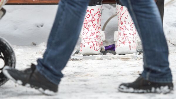 Мужчина проходит мимо женщины у остановки зимой. Архивное фото - Sputnik Кыргызстан