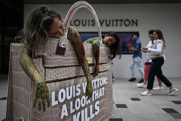 Зоозащитники возле магазина Louis Vuitton в Куала-Лумпуре (Малайзия) во время акции протеста против использования компанией питонов для изготовления сумок и кошельков из змеиной кожи - Sputnik Кыргызстан