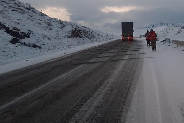На перевале Тоо-Ашуу идет снег, работники ДЭУ №9 очищают трассу от снега и посыпают противоскользящими материалами - Sputnik Кыргызстан