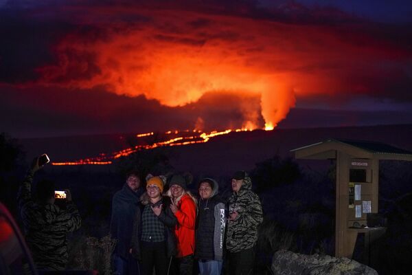 Люди позируют на фоне извержения лавы из вулкана Мауна-Лоа недалеко от города Хило, Гавайи - Sputnik Кыргызстан