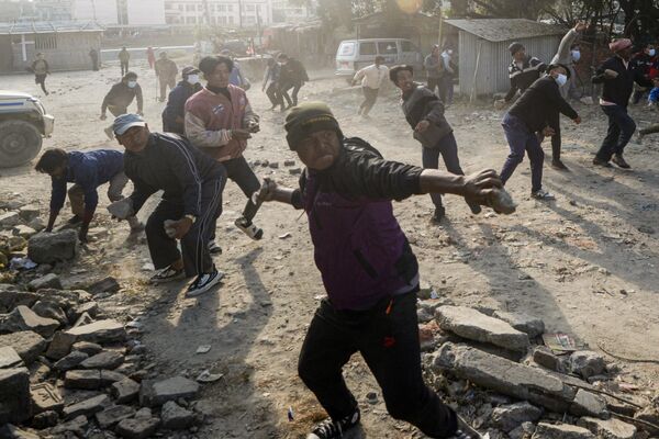 Митингующие бросают камни в полицию, выступая против решения властей выселить безземельных скваттеров (скотоводов), проживающих в разных частях города. Катманду, Непал. - Sputnik Кыргызстан