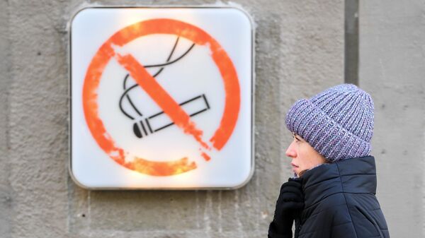 Женщина около таблички курение запрещено. Архивное фото - Sputnik Кыргызстан