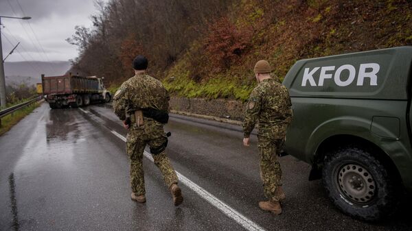 Солдаты НАТО осматривают дорожную баррикаду возведенную сербами возле города Зубин-Поток в Косово - Sputnik Кыргызстан