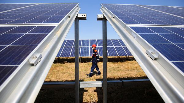 Сотрудник осматривает солнечные панели на солнечной электростанции. Архивное фото - Sputnik Кыргызстан