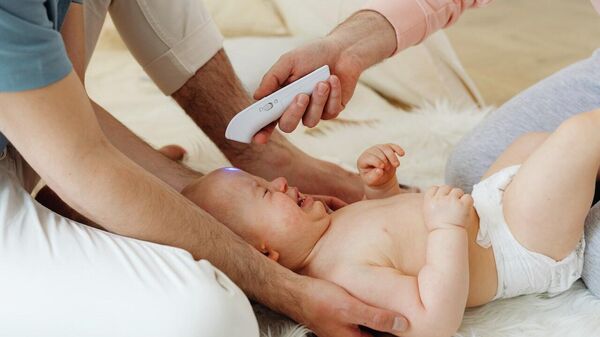 Мужчина проверяет температуру у ребенка. Иллюстративное фото - Sputnik Кыргызстан
