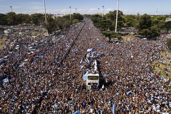 Аргентинская сборная по футболу, выигравшая чемпионат мира, едет в открытом автобусе во время парада в Буэнос-Айресе - Sputnik Кыргызстан