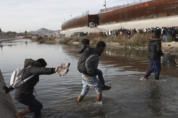 Мигранттар Рио-Гранде суусун кесип өтүп, Сьюдад-Хуарестеги (Мексика) Американын чек арасын көздөй бараткан учурдан бир ирмем - Sputnik Кыргызстан