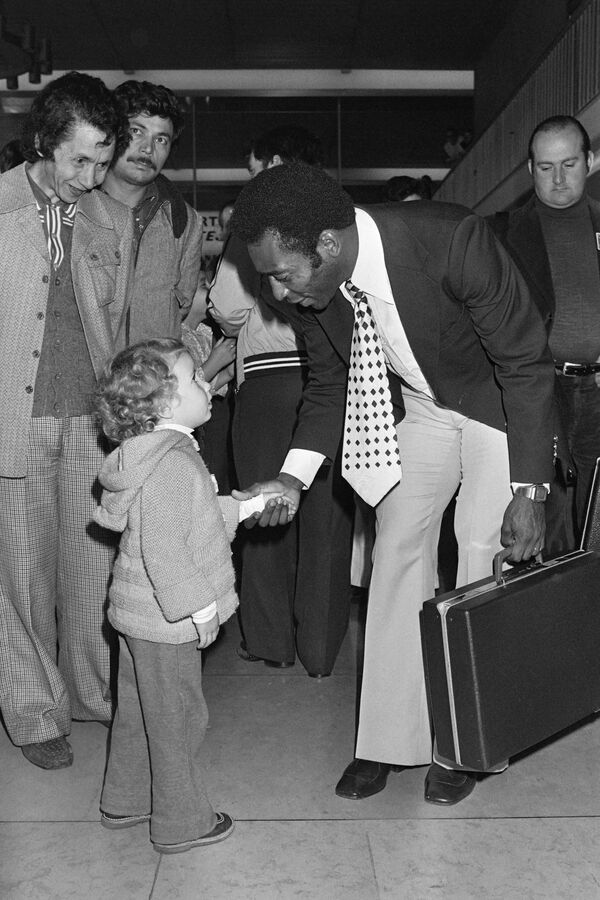 Пеле пожимает руку ребенку в аэропорту Орли, куда он прибыл с командой &quot;Нью-Йорк Космос&quot; на товарищеский матч против &quot;Пари Сен-Жермен&quot;, 1976 год - Sputnik Кыргызстан