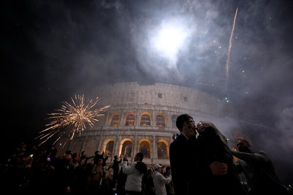 Пара целуется во время новогоднего фейерверка в центре Рима на фоне древнего Колизея - Sputnik Кыргызстан