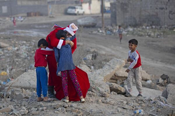 Мохаммед Мааруф в костюме Санта-Клауса раздает подарки детям в трущобах города Басра (Ирак) - Sputnik Кыргызстан