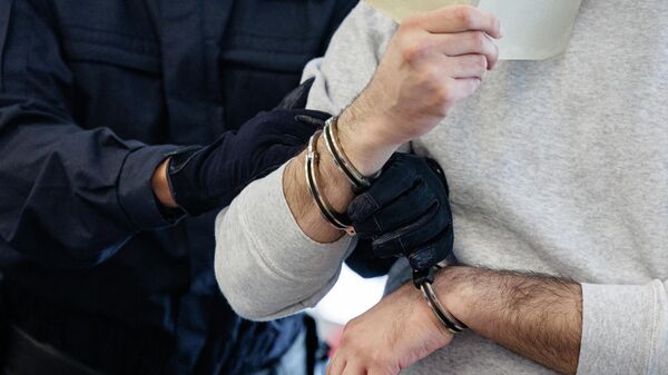 Мужчину ведут в наручниках. Архивное фото - Sputnik Кыргызстан