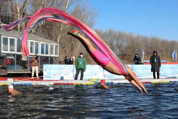 Любитель зимнего плавания ныряет в бассейн на берегу реки в Шэньяне (Китай) - Sputnik Кыргызстан