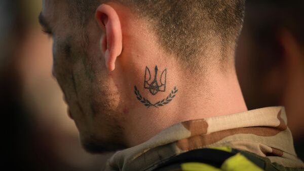 Украиналык жоокер мойнунда украин герби менен татуировканы көрсөтүп жатат. Архив - Sputnik Кыргызстан