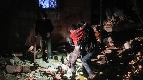 Сириядагы жер титирөөдөн кийин киши жарадар болгон баланы көтөрүп кетип атат - Sputnik Кыргызстан