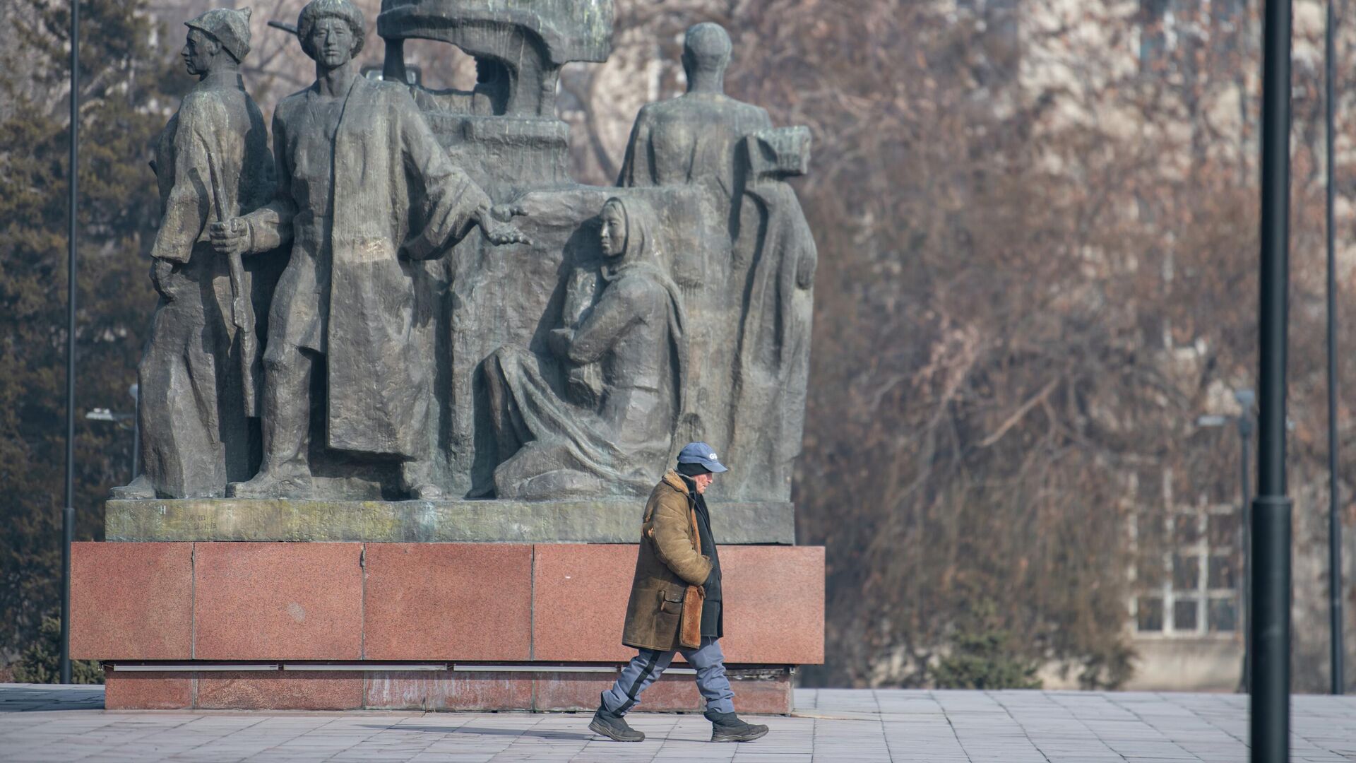 Пожилой мужчина проходит мимо памятника борцам революции в Бишкеке - Sputnik Кыргызстан, 1920, 16.02.2023
