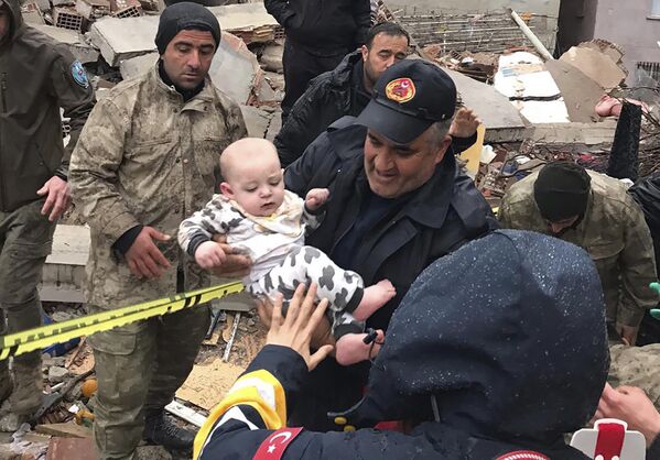 Спасатели вытаскивают младенца из разрушенного здания в Малатье (Турция) - Sputnik Кыргызстан