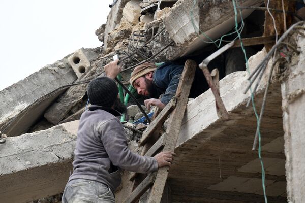 Один мужчина помогает  другому выбраться из-под завалов в Джандарисе - Sputnik Кыргызстан