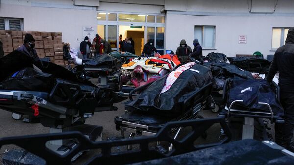 Люди стоят рядом с телами жертв землетрясения в больнице в Эльбистане, юго-восточная Турция - Sputnik Кыргызстан