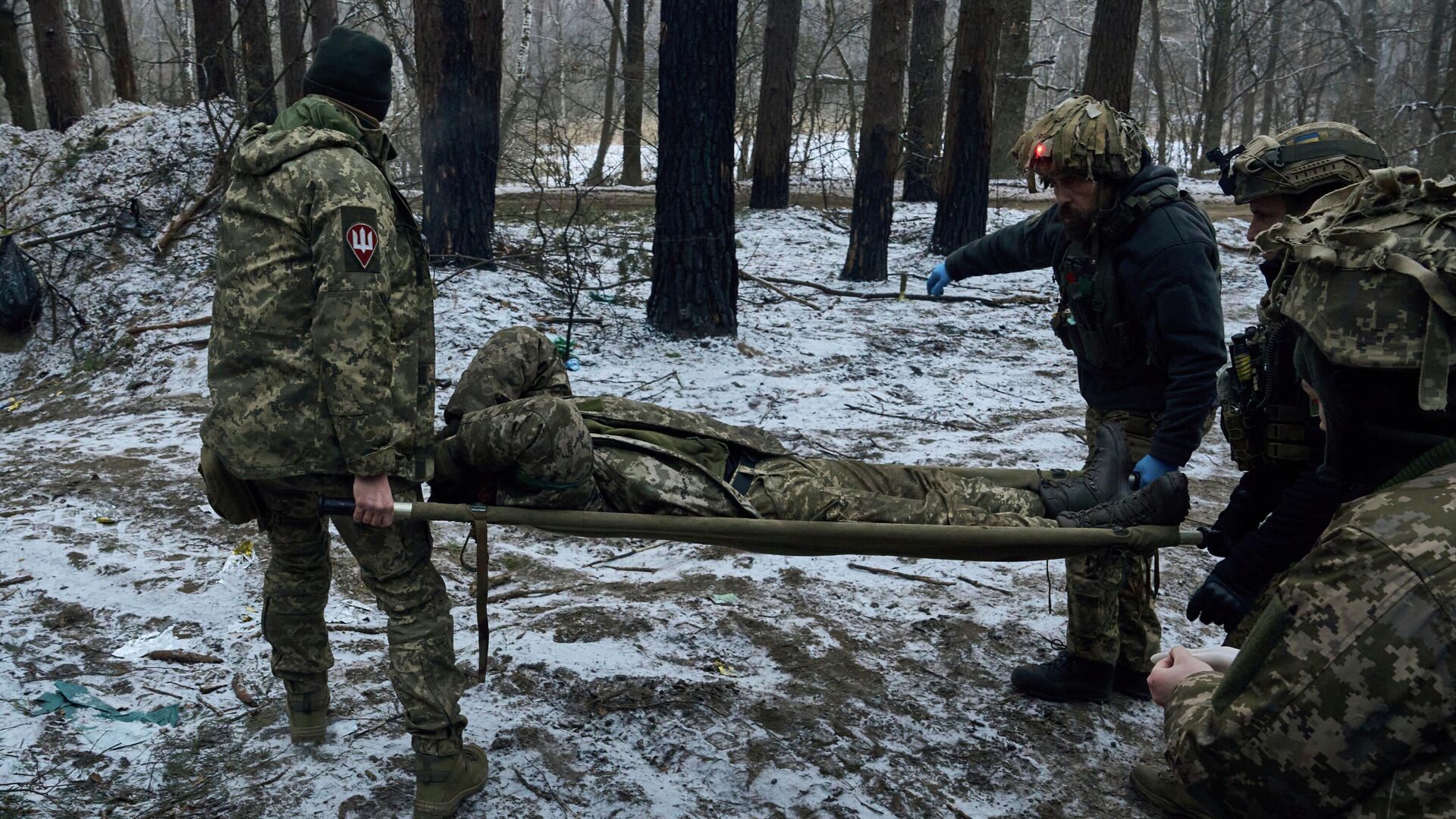 Военные медики несут раненого солдата в эвакуационную машину возле Кременной, Украина - Sputnik Кыргызстан, 1920, 21.02.2023