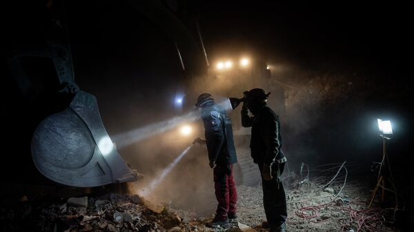 Спасатели осматривают ковш экскаватора в поисках тел людей, погибших во время землетрясения в Турции - Sputnik Кыргызстан