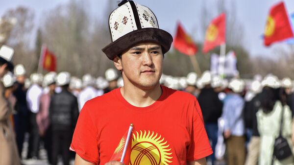 Парень с символикой флага КР на на площади Ала-Тоо в Бишкеке. Архивное фото - Sputnik Кыргызстан
