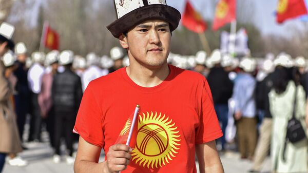 Парень с символикой флага КР на на площади Ала-Тоо в Бишкеке. Архивное фото - Sputnik Кыргызстан